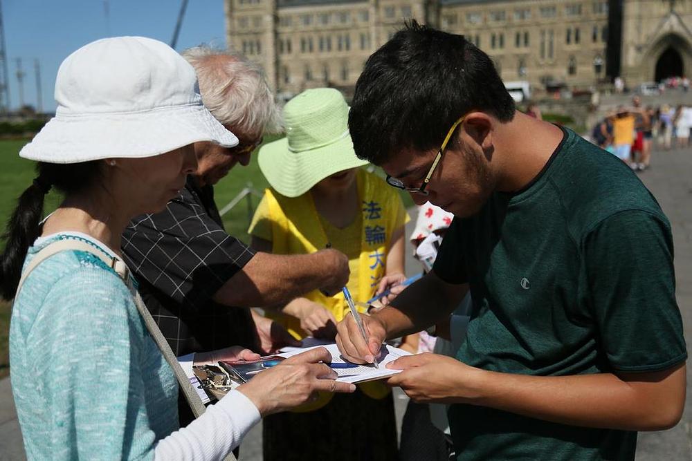 Kanadski građani potpisuju peticije ispred Parliament Hilla kako bi osudili progon Falun Gonga.