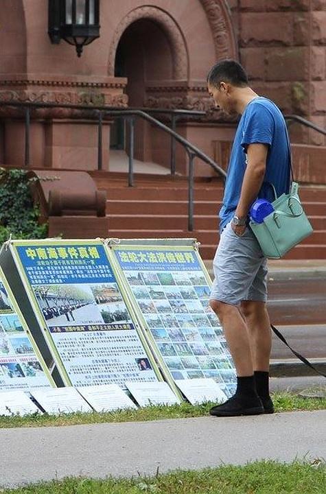 Prolaznik čita plakate na kojima se predstavlja Falun Gong i podiže svijest o progonu ove prakse u Kini, koji traje već 17. godina. 