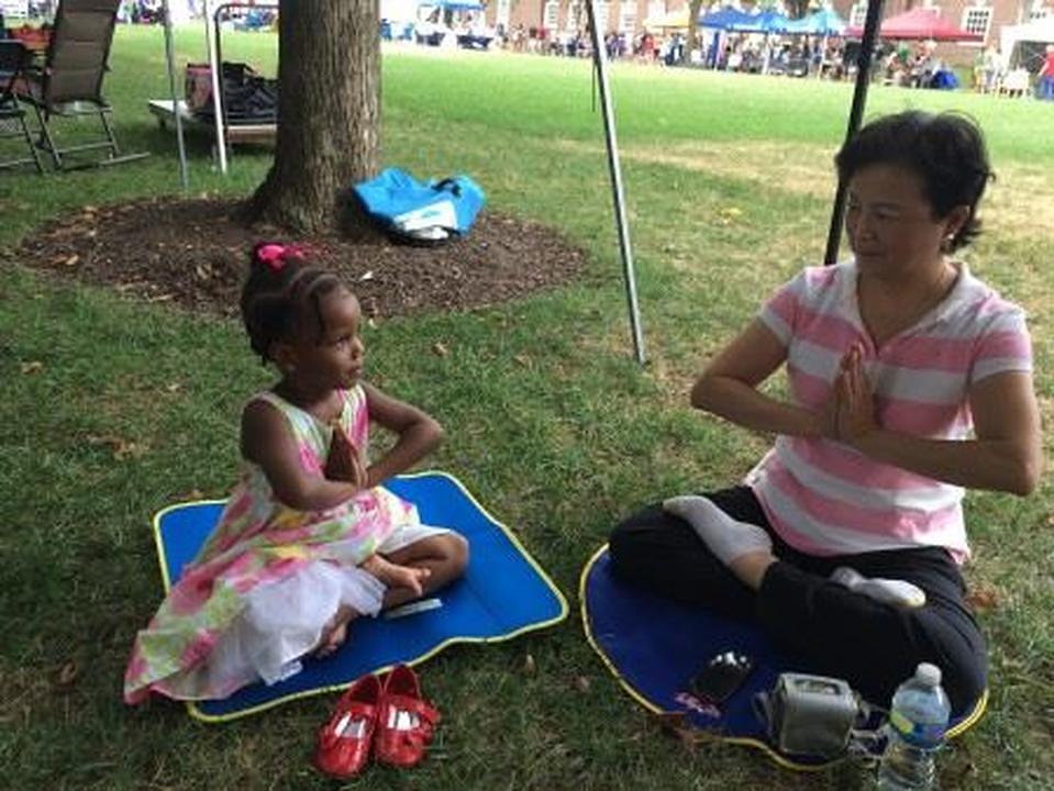 Mlada posjetiteljka festivala uči Falun Gong vježbe. 