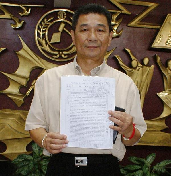 Član Gradskog vijeća Cheng Chin-long, inicijator rezolucije, drži dokument u rukama.