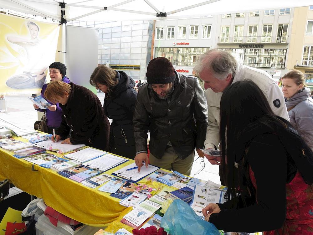 Ljudi potpisuju peticiju da bi osudili progon Falun Gonga u Kini.