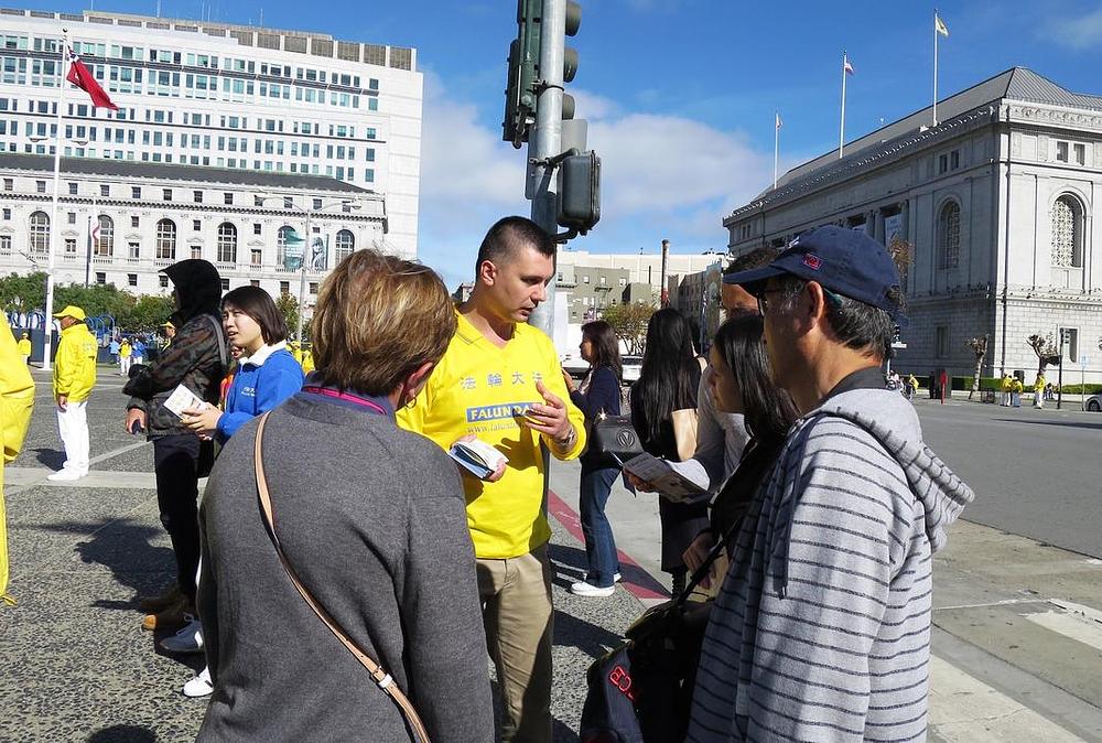 Praktikant objašnjava prolaznicima šta je Falun Dafa i govori o njegovom progonu u Kini.