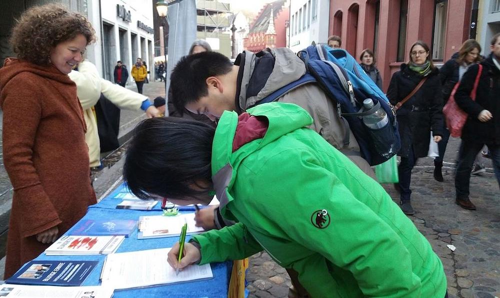 Kineski par potpisuje peticiju.