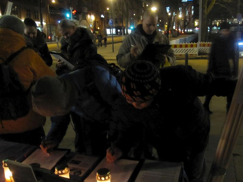 Prolaznici potpisuju peticiju podrške Falun Gongu.