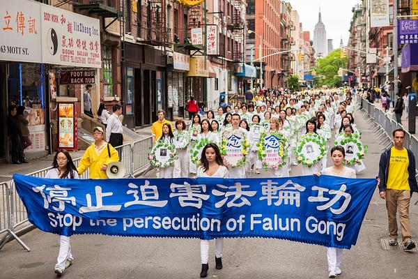 Natpis na transparentu, „Zaustavite progon Falun Gonga“