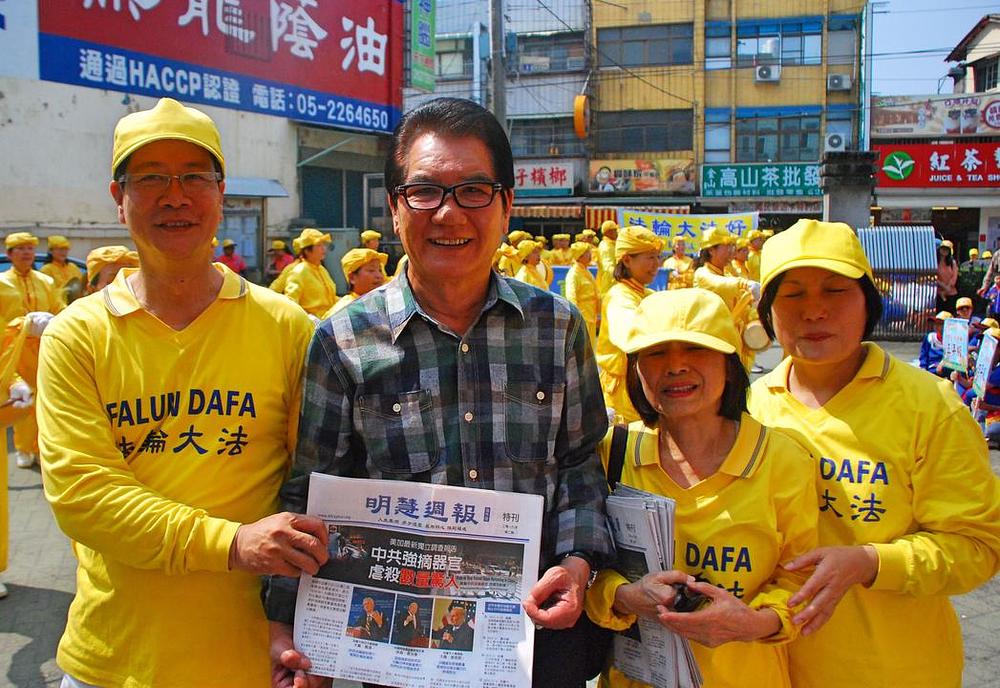 Sekretar Lin Chun-mu iz ureda općine Meishan pozira za grupnu fotografiju sa praktikantima Falun Gonga.