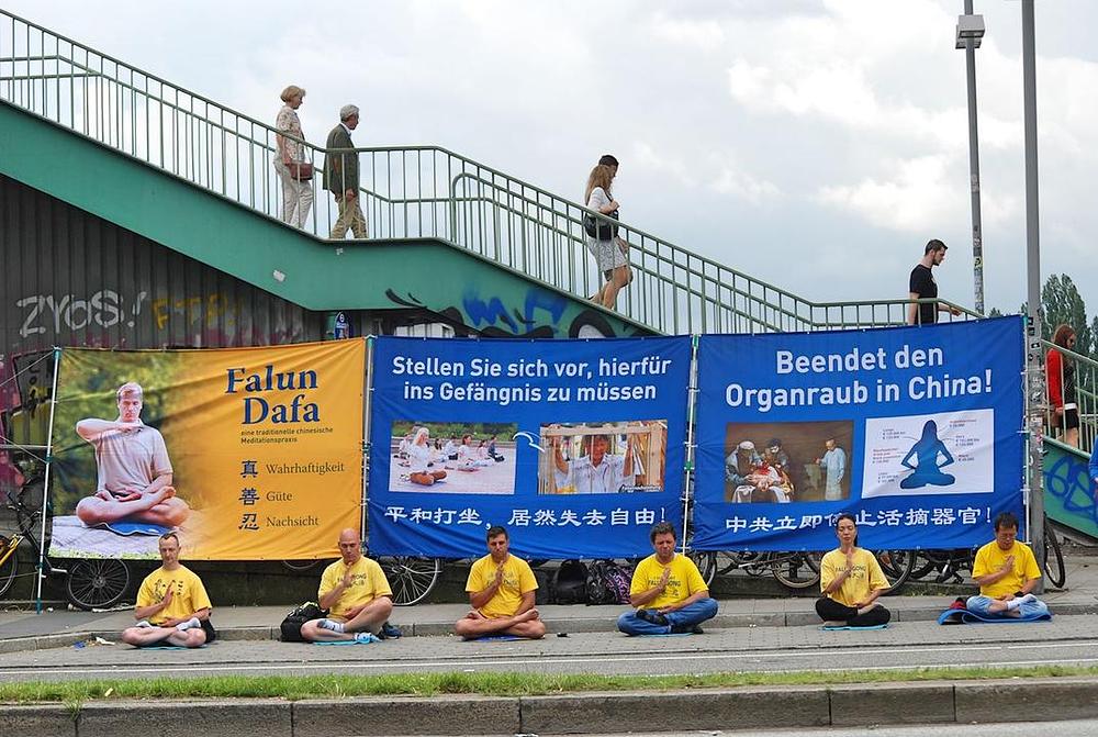 Praktikanti Falun Gonga meditiraju i drže istaknute transparente za vrijeme samita G20 u Hamburgu u Njemačkoj  