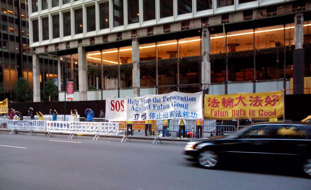 Transparent istaknut ispred Waldolf Astoria hotele nosi tekst: „ Pomozite zaustaviti progon Falun Gonga“ i „Falun Gong je dobar.“