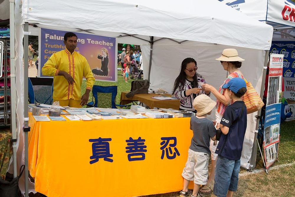 Ljudi su se zaustavljali kraj praktikantskog štanda da saznaju više o Falun Dafa.