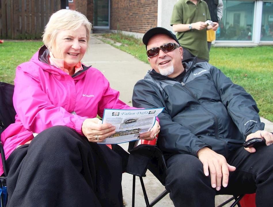 Carolyn (lijevo) je rekla čitajući Falun Gong letak: "Sretna sam što vidim ovaj orkestar."