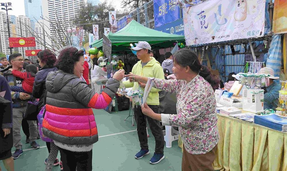 Gđa Shi dijeli lotosove cvjetove pored Falun Gong stola na Kinesku novu godinu 