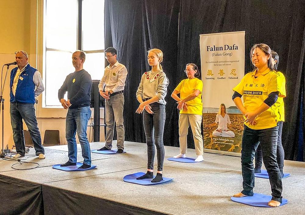 Falun Dafa praktikanti demonstriraju vježbe na sceni. 