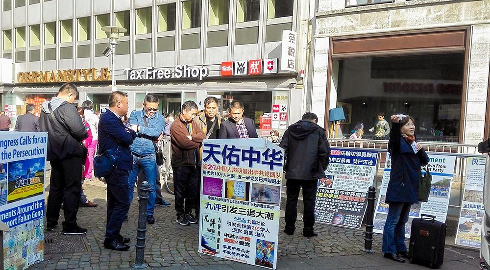 Kineski turisti gledaju Falun Gong materijale ispred katedrale u Kelnu u Njemačkoj.