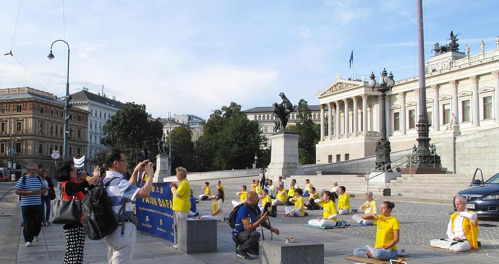 Turisti slikaju izvođenje vježbi.