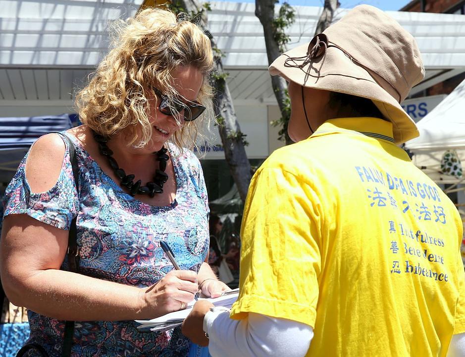 Ljudi potpisuju peticiju i osuđuju progon u Kini.