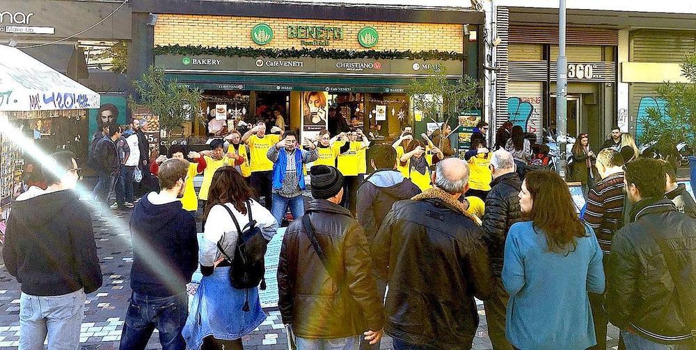 Ljudi gledaju demonstraciju vježbi na željezničkoj stanici.