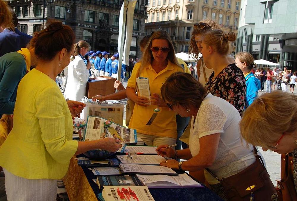 Prolaznici potpisuju peticiju kojom osuđuju ubijanje praktikanata zbog uzimanja njihovih organa. 