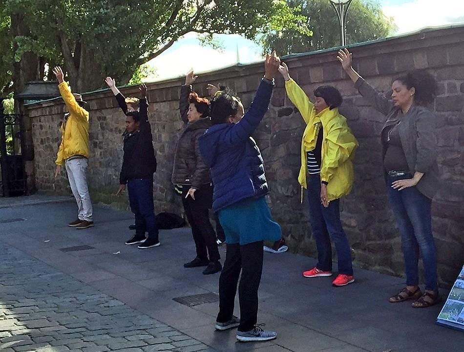 Žena u prvom redu je željela naučiti vježbe. Nakon što je izvela treću vježbu, oči su joj bile pune suza. Ona je zagrlila praktikanta koji ju je podučavao i kazala: „Ovo je tako lijepo, moram to naučiti.“