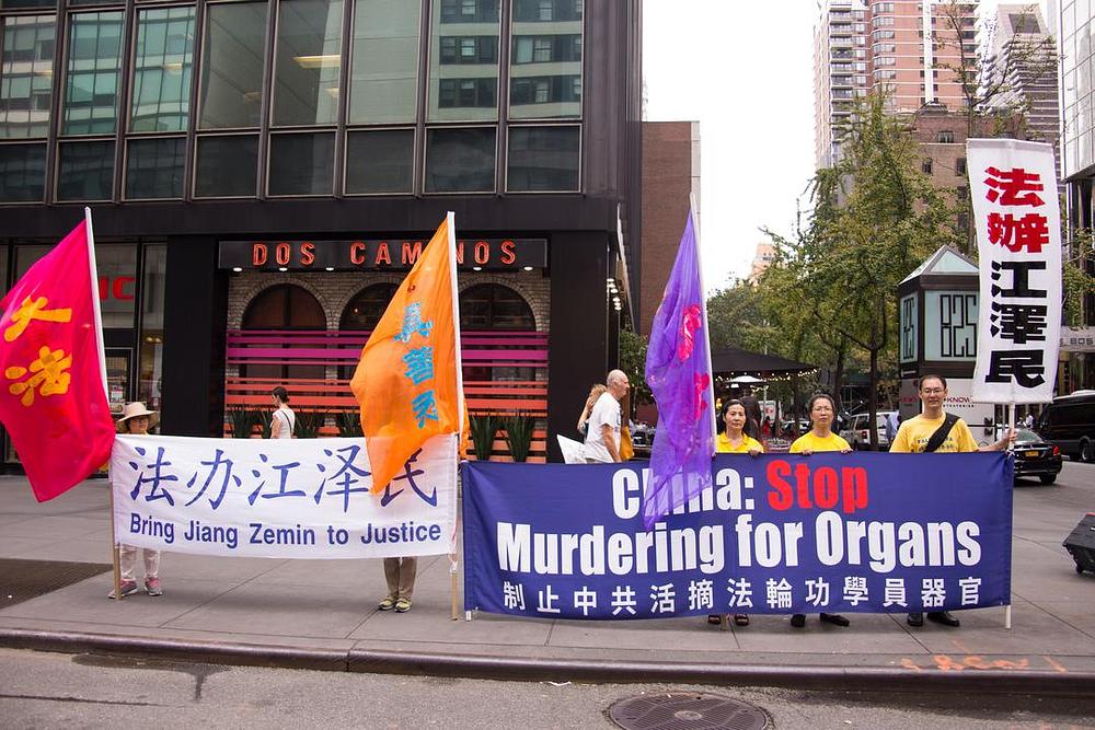 Transparenti u centru Manhatana pozivaju na privođenje Jianga pred lice pravde (na engleskom i kineskom jeziku). 