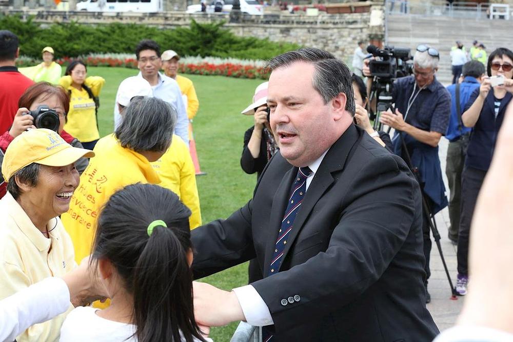 Član parlamenta Jason Kenney se rukuje sa praktikantima. 
