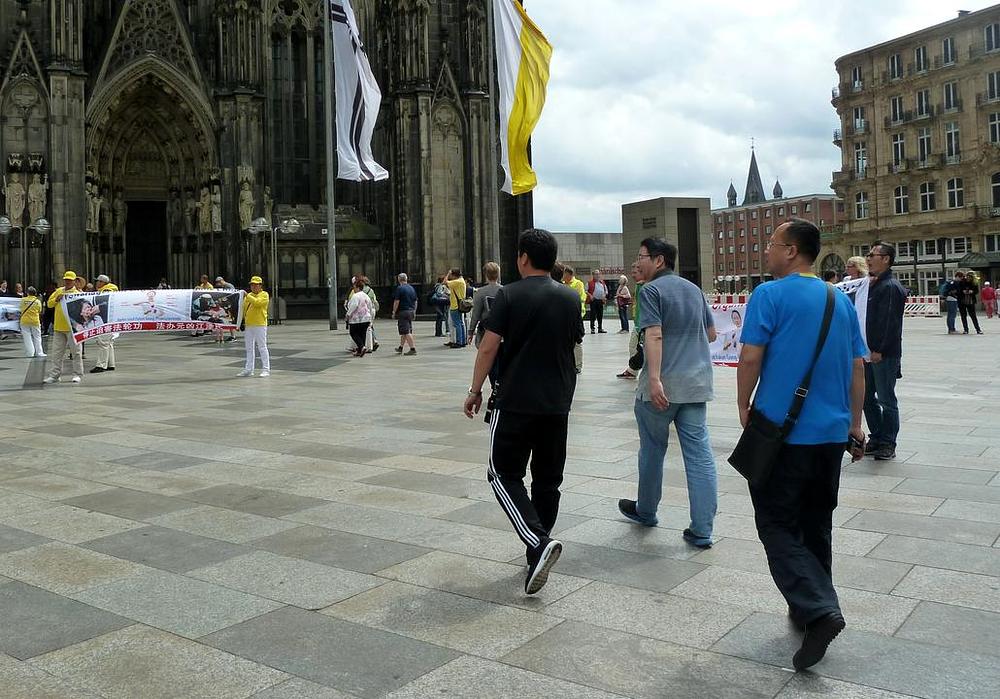 Kineski turisti čitaju transparente praktikanata