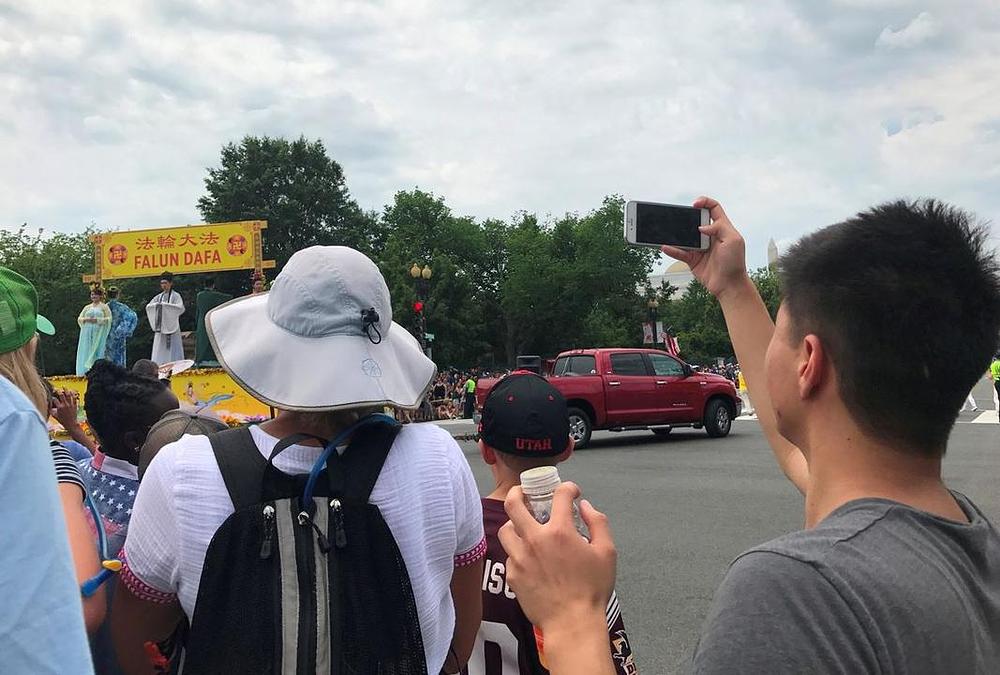 Kineski turisti fotografiraju Falun Gong praktikante 