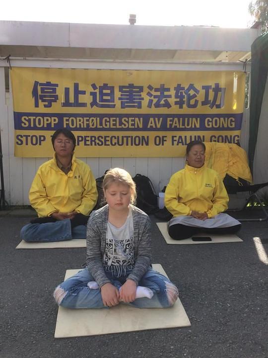 Djevojčica uči izvoditi sjedeću meditaciju.