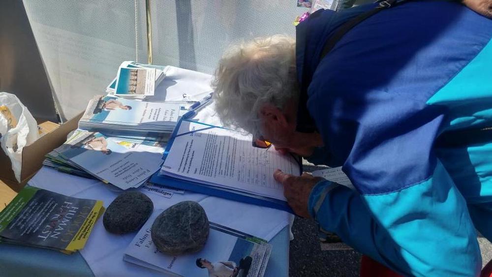 Ljudi se informišu o progonu i potpisuju peticiju za njegovo okončanje.