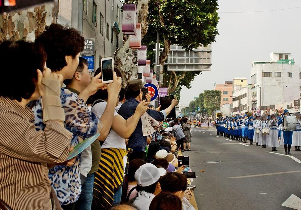 Gledaoci gledaju Tian Guo Marching Band.