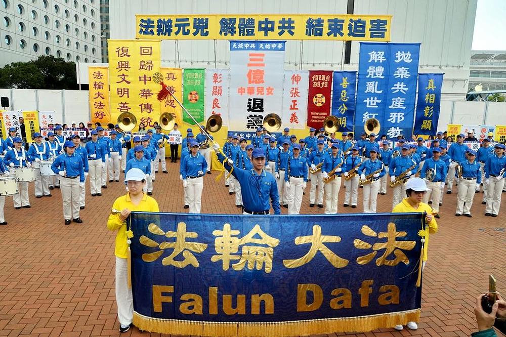 Falun Gong praktikanti i građani Hong Konga su održali skup na trgu Edinburgh 18. marta 2018. godine kako bi proslavili izbor skoro 300 miliona kineskih ljudi da napuste Kinesku komunističku partiju i njoj pripadajuće omladinske organizacije