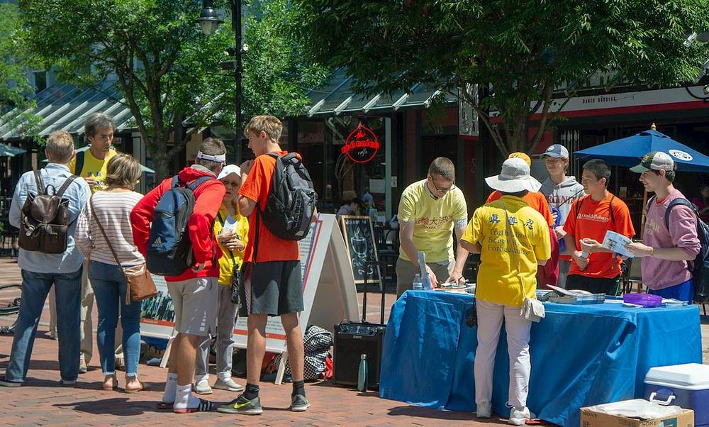 Prolaznici potpisuju peticiju koja podržava mirni otpor Falun Gonga 