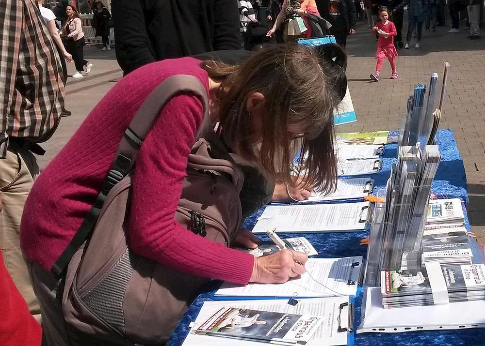 Ljudi potpisuju peticiju osuđujući progon u Kini.