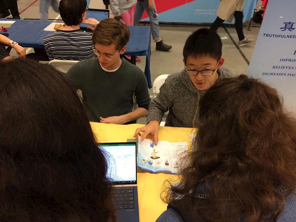 Mladi praktikanti pomažu na Falun Dafa štandu na manifestaciji Noć aktivnosti na McGill univerzitetu.