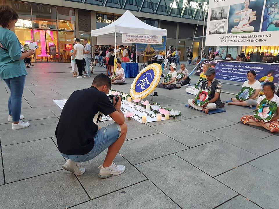 Prolaznici posmatraju bdijenja uz svijeće, kojim praktikanti tuguju za onima koji su u progonu izgubili živote.