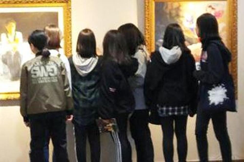 Grupa srednjoškolaca dirnuta slikama. 