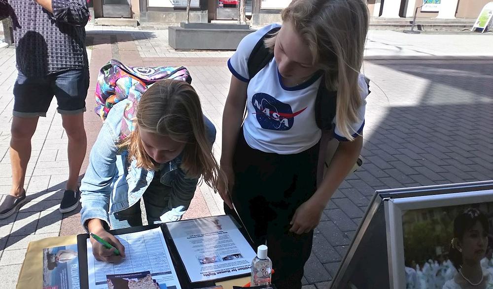 Učeničina prijateljica potpisuje peticiju.