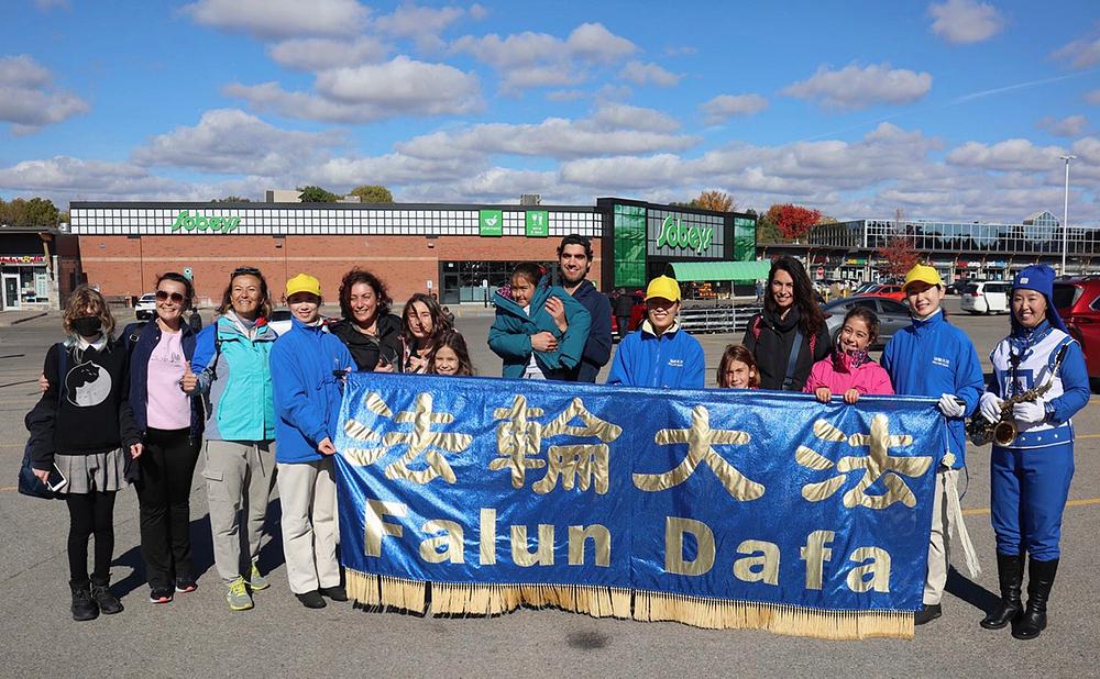 Aiseunr (četvrta s desna) i njena porodica i prijatelji fotografišu se sa članovima orkestra.