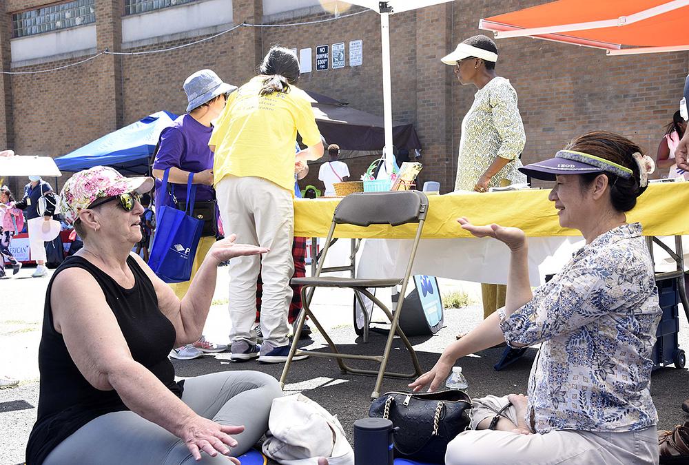 Stanovnica (lijevo) uči petu Falun Dafa vježbu.