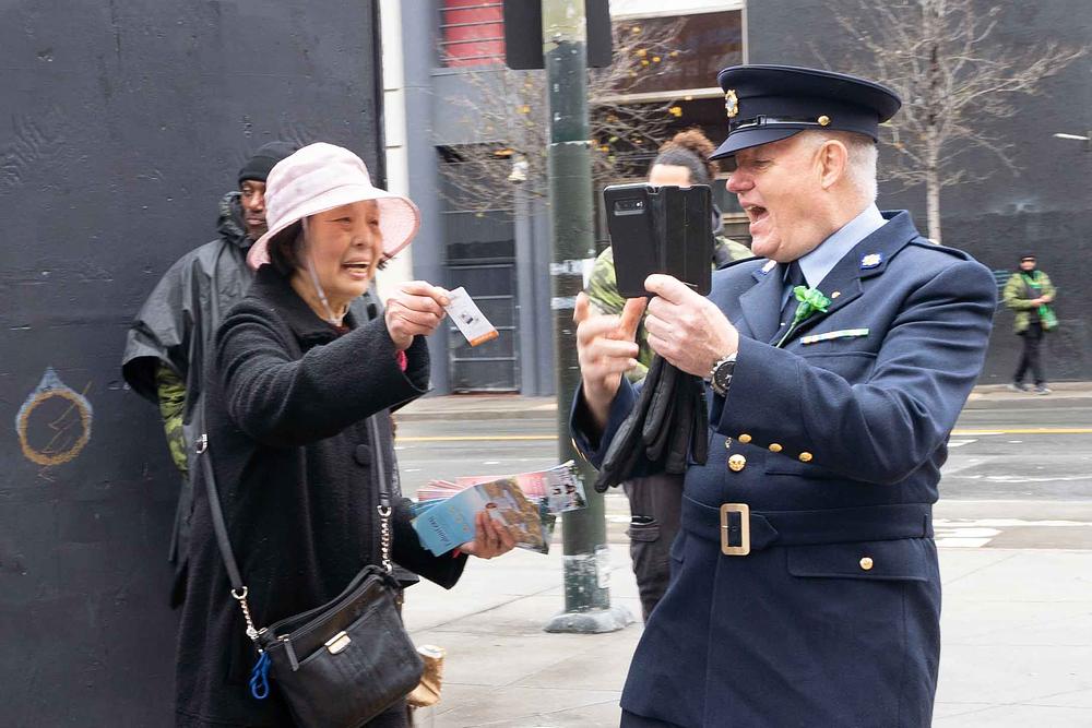 Praktikanti su dijelili informativne letke o Falun Dafa duž rute parade.