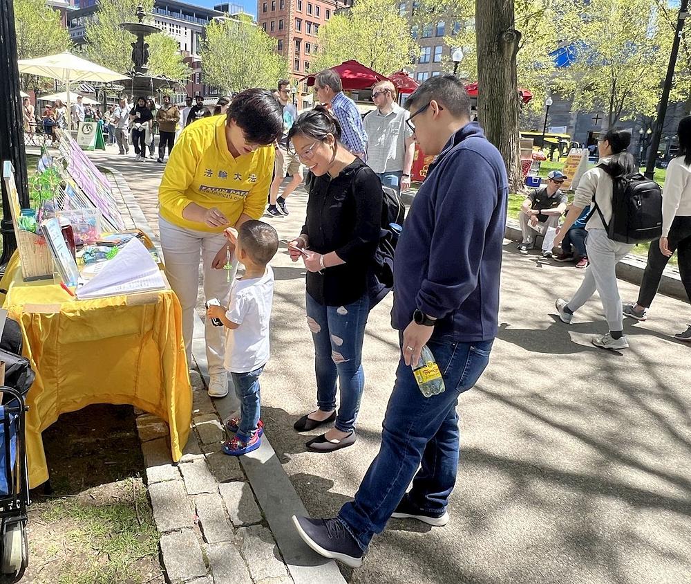 Lien Seng i njegova žena i sin dobijaju lotosov cvet od praktikantkinje.